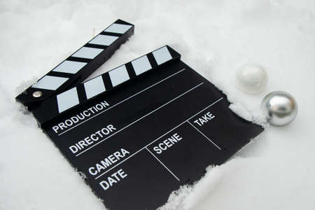 Clapper board in the snow with Christmas elementsの写真素材