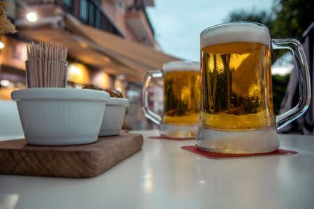 Two glasses of beer with reflection of street lights