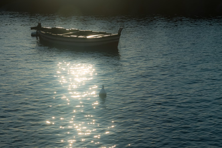 Woden boat at sunrise after fisherman come backの写真素材