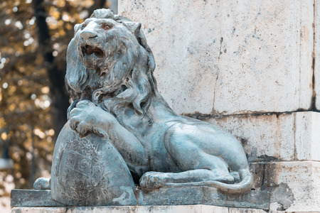 Bronze lion placed on the base of a monumentの写真素材