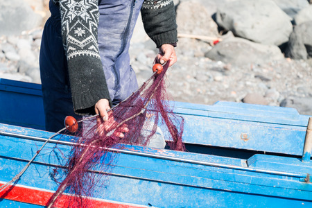 Sicilian Fisherman with nets and woden boat