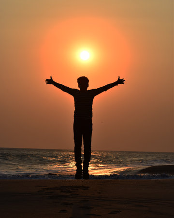 Silhouette of a man on the beach against the setting sun