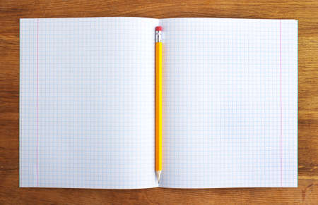 pencil and notebook on wood