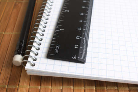 closeup of pencil, spiral notebook and ruler