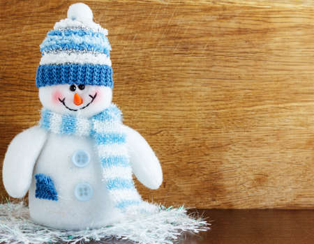 Snowman on a wood background close upの写真素材