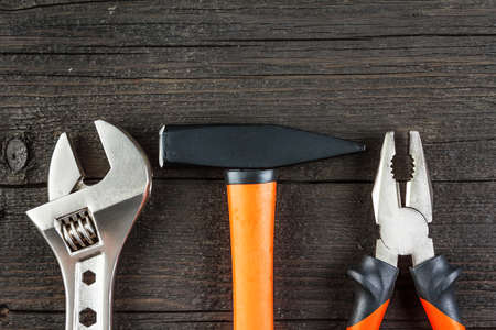 Spanner, hammer and pliers on wood close-upの写真素材