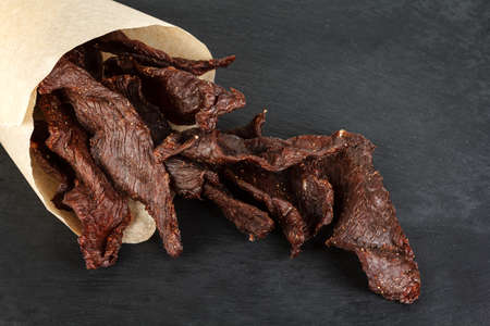 Beef jerky on a slate plate close-upの写真素材