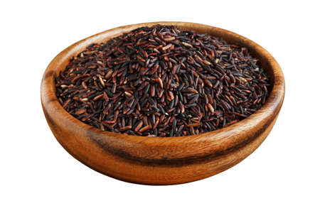 Black rice in a wooden bowl isolated on whiteの写真素材
