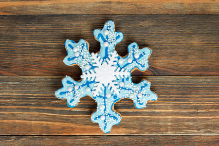Close-up of gingerbread in a shape of a snowflake on wood backgroundの写真素材