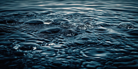 Water drops on the surface of the water. Abstract background. Toned.の素材