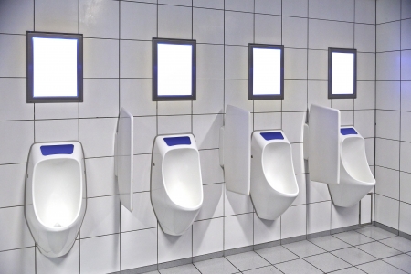 modern restroom interior with urinal row and frame for advertisementの写真素材