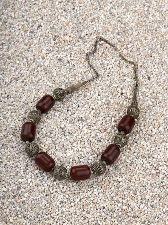 Ethnic necklace with shells on he sand of a beach.の写真素材