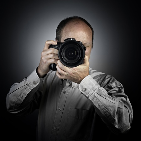 a man with photo camera on greyの写真素材