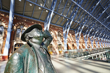 LONDON - JUNE 8. Standing in the restored and redeveloped St Pancras International rail station is a statue of Sir John Betjeman who saved the building from demolition; June 8, 2014 in London, UK.のeditorial素材