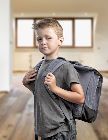 Young boy with backpack isolated on white background ready to go back to schoolの写真素材