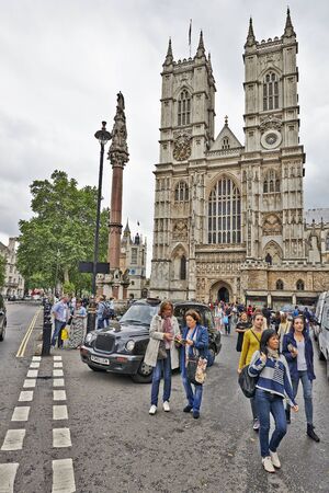 LONDON, UK - JUNE 07, 2014:  Some tourists and visitors wander outside the entrance to Westminster Abbeyのeditorial素材