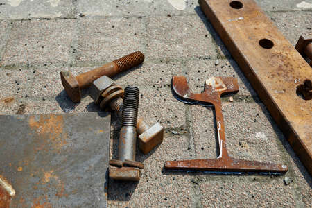 Three big bolts and a key on the groundの写真素材