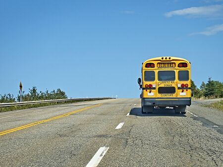 Back to school.School bus on the road from behind