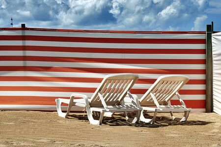 Two long chairs on Belgian coast protected from windの写真素材