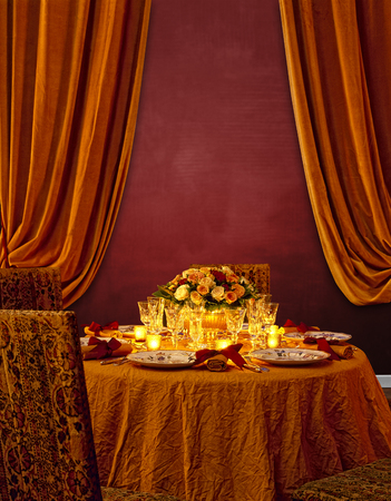 Luxurious festing table against Red textured wall and orange curtainsの写真素材