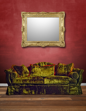 Luxurious green velvet sofa with textured red wall and alu frames hanging