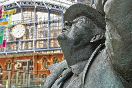 LONDON - JUNE 7. Standing in the restored and redeveloped St Pancras International rail station is a statue of Sir John Betjeman who saved the building from demolition; June 7, 2014 in London, UK.のeditorial素材