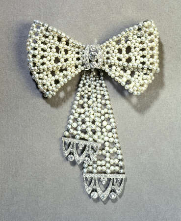 Beautifull pearl tie brooch on textured paperの写真素材