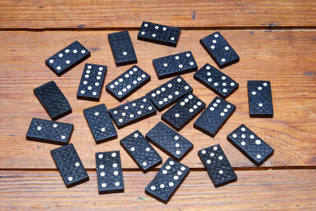 Some black dominoes on grungy wooden table