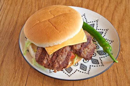 Pork burger on decorated plate on wooden textured tableの写真素材