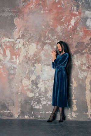 slim brunette in a blue velvet dressの写真素材