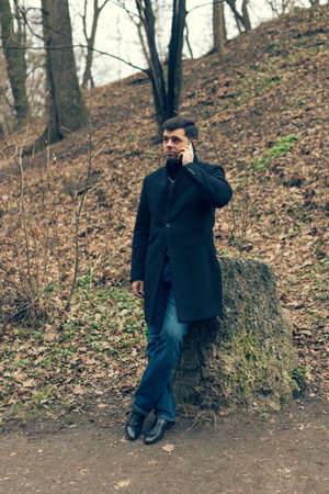 A man in a coat walks in the spring parkの写真素材