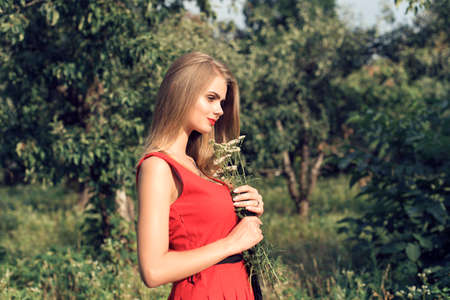Blonde in bright red dressの写真素材