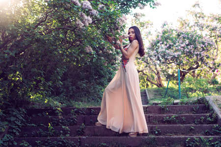 Girl in a long dress walking in the botanical gardenの写真素材