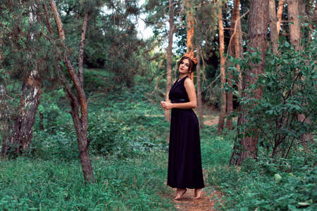 Slender brunette in a black dress in the parkの写真素材