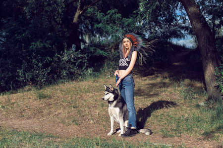 A girl with a dog in an Indian headdress