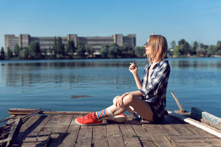 The girl on the shore of the urban lakeの写真素材