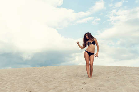 Walk with a brunette on the hot sandの写真素材