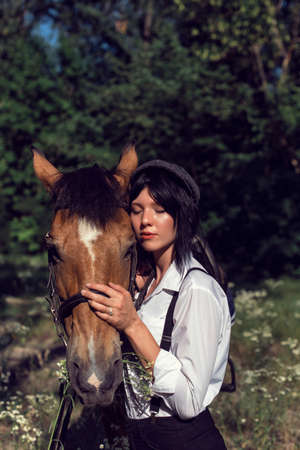 Summer walk of the girl with a brown horseの写真素材
