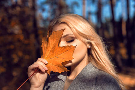 Autumn walk in the park with a cute blondeの写真素材