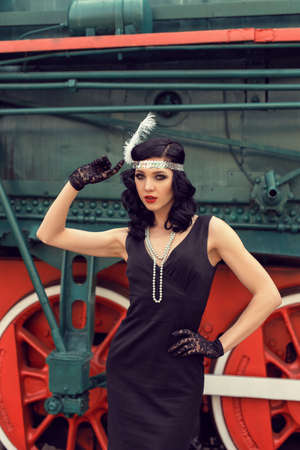 Young girl at the retro train stationの写真素材