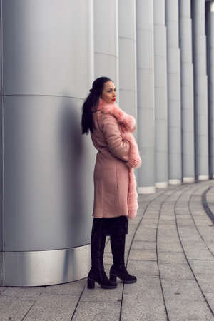 Brunette in the city in a pink coatの写真素材