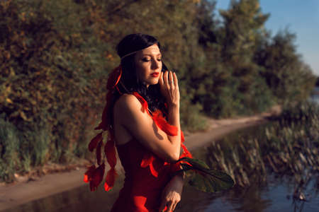 Young girl in red by the riverの写真素材