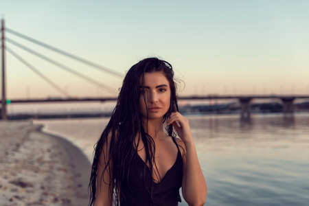 Brunette on the beach near the bridgeの写真素材