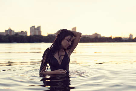 Brunette on the beach near the bridgeの写真素材