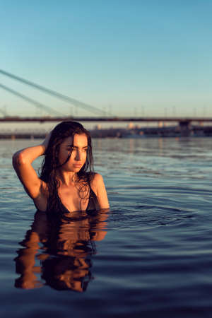 Brunette on the beach near the bridgeの写真素材