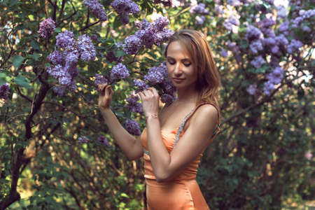 Walk with a young woman in the lilac flowering seasonの写真素材