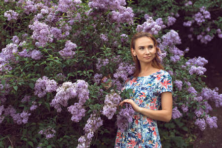 Walk with a young woman in the lilac flowering seasonの写真素材