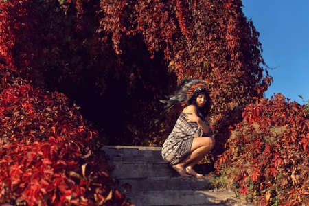 Girl in the park in an American headdressの写真素材