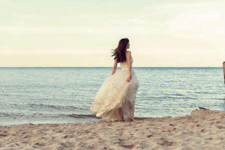 Bride in a white dress by the seaの写真素材