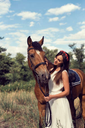 Girl in a field on a brown horseの写真素材